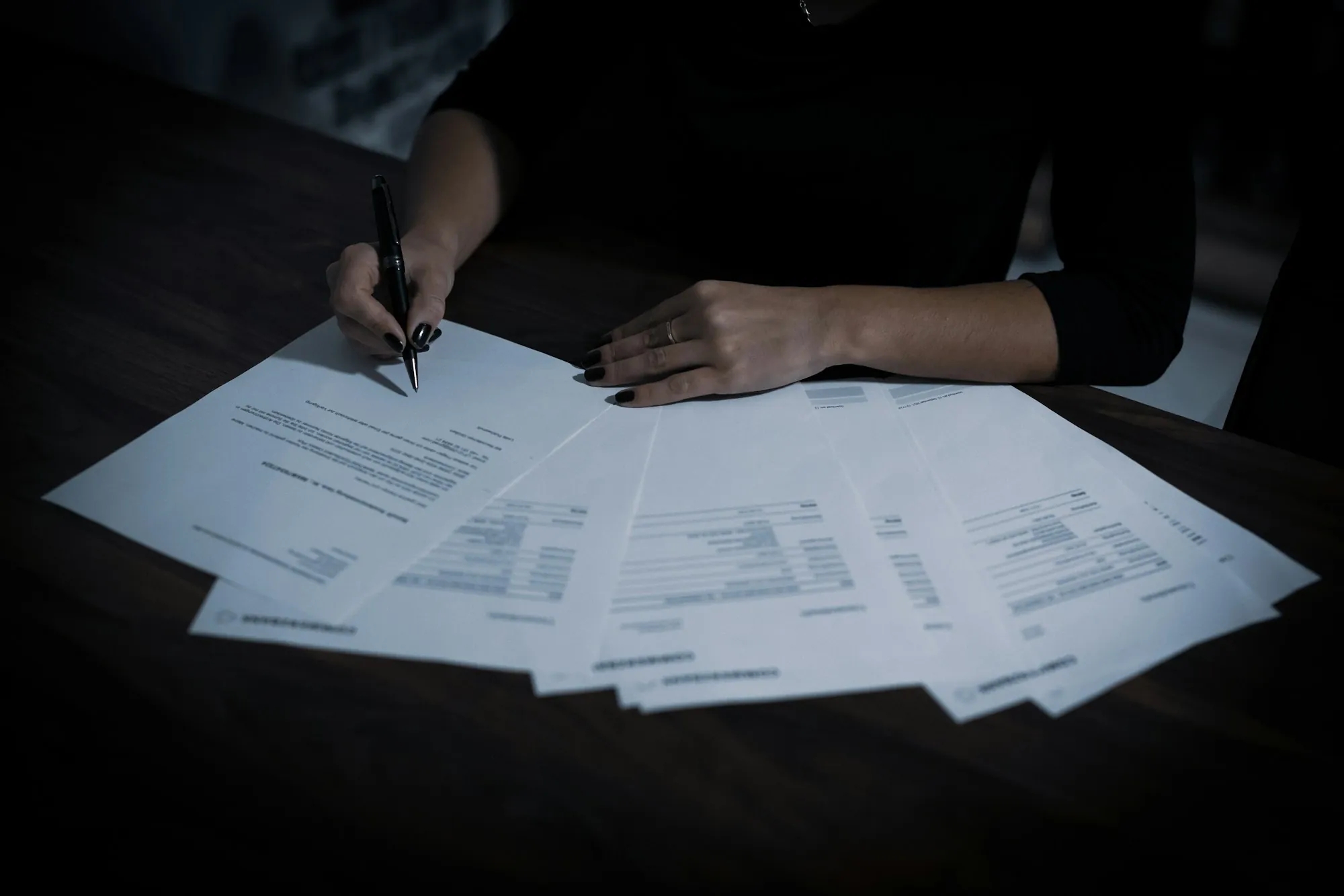 Documents spread out on a dark desk