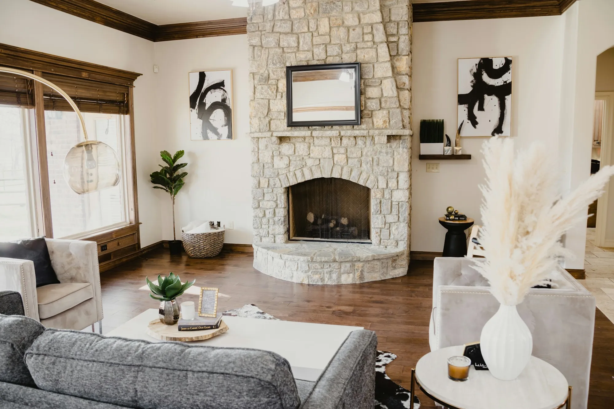 Living room with a stone fireplace and light gray sofas