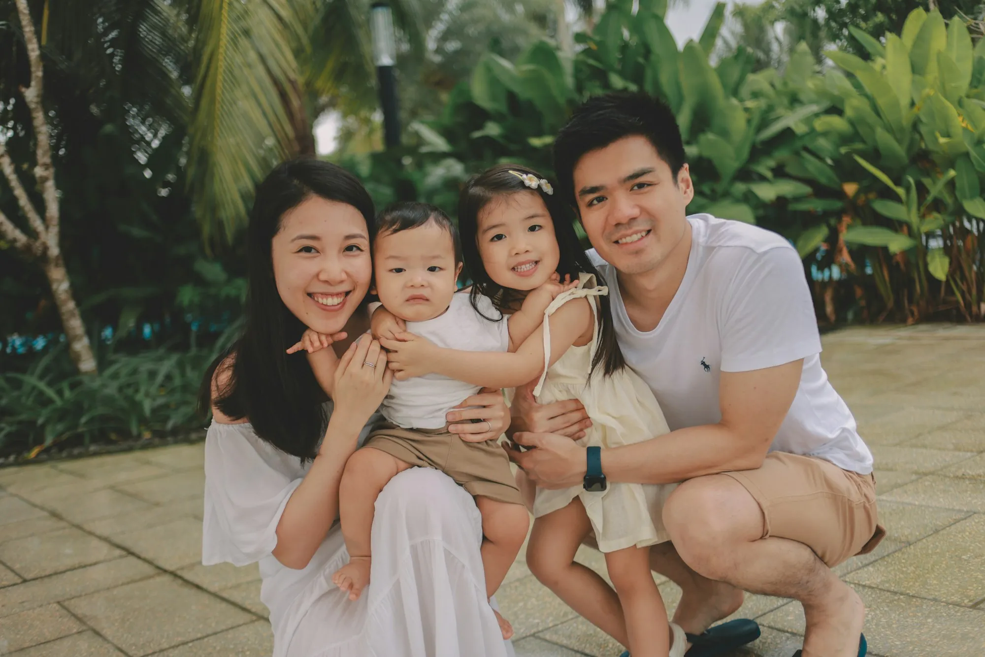 Young family with two small children smiling outdoors